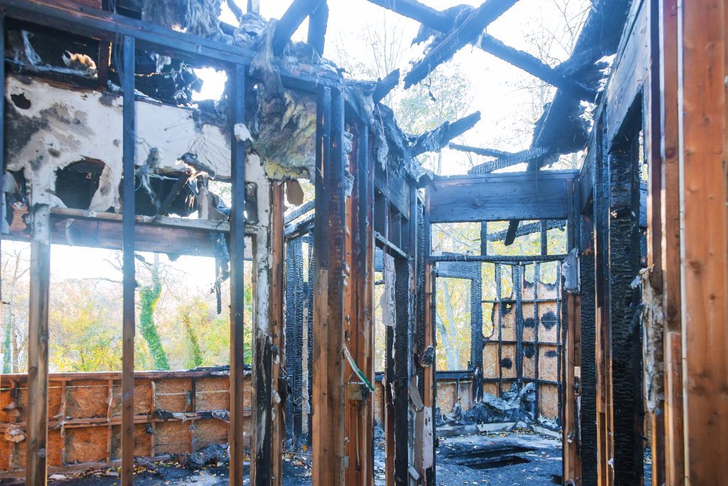 Home after fire and burned wooden wall in the area.
