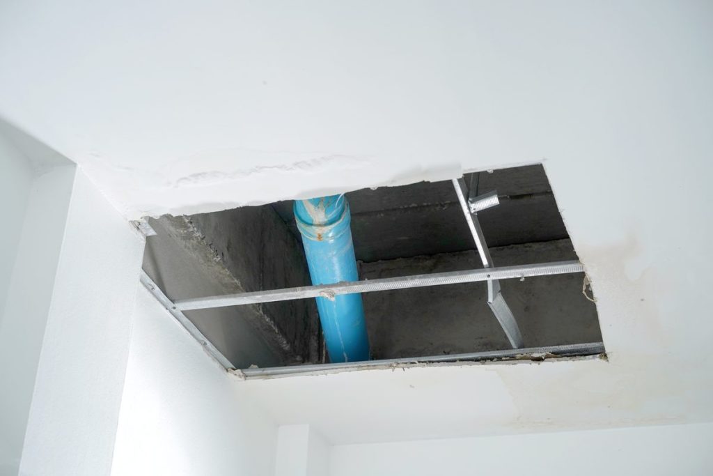 Opened ceiling exposing a leaking pipe in a commercial building