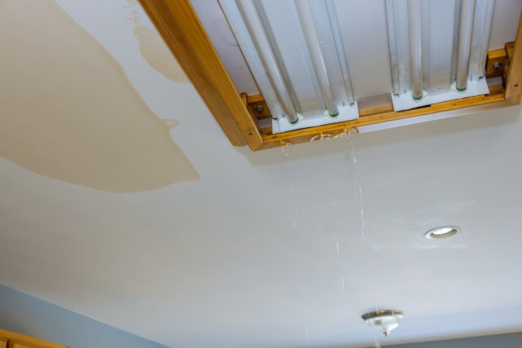 Water leaking through a ceiling from the floor above