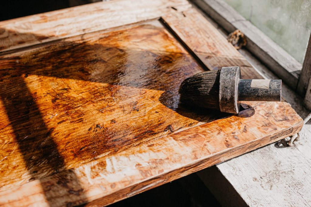 Craftsperson restoring the surface of water-damaged wooden furniture