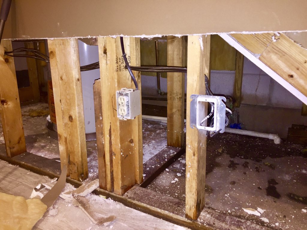 Open wall framing and wet subfloor after water damage